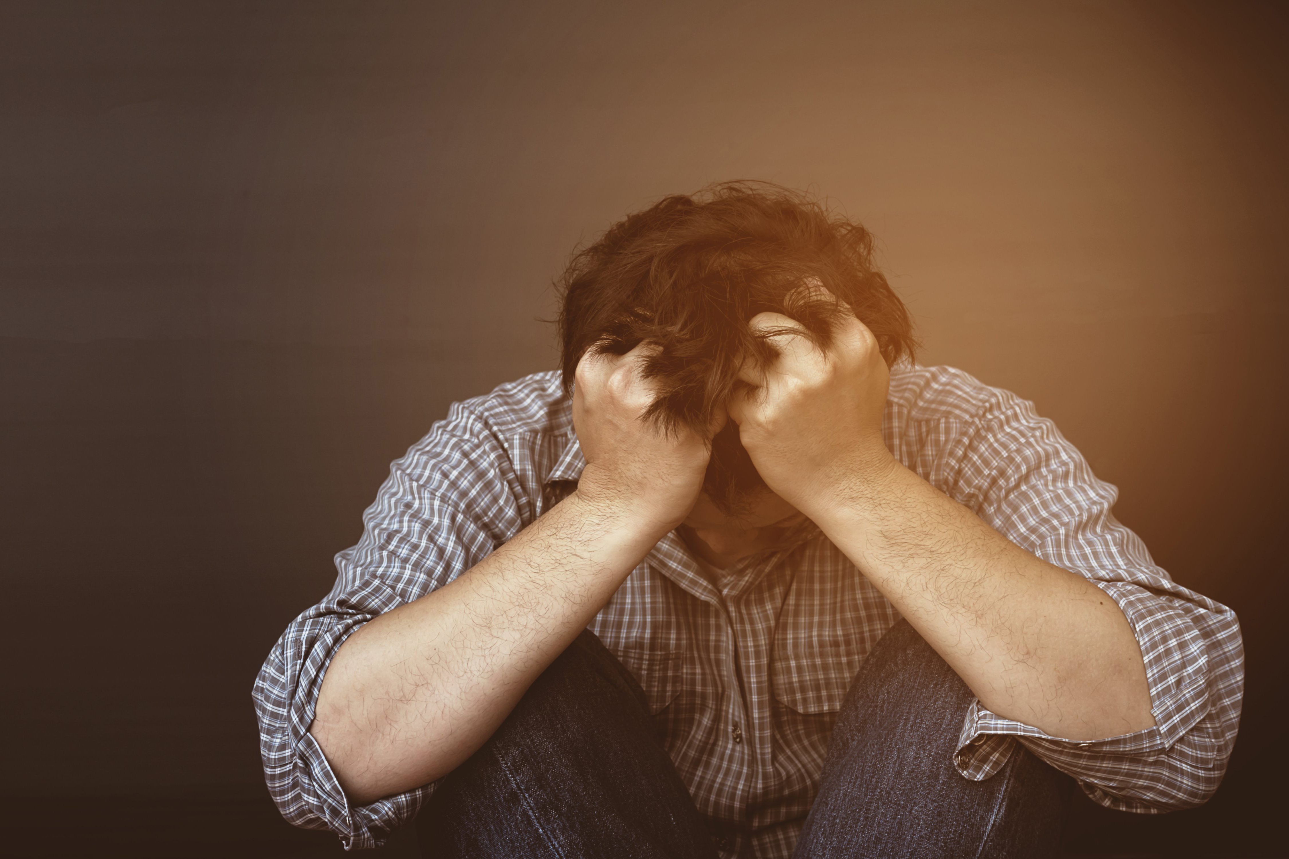 Image d'une homme qui se serre la tête en emprise au stress